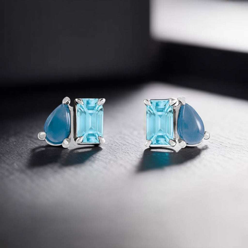 Sky Blue Topaz & Natural London Blue Topaz Two-Stone Stud Earrings on window sill
