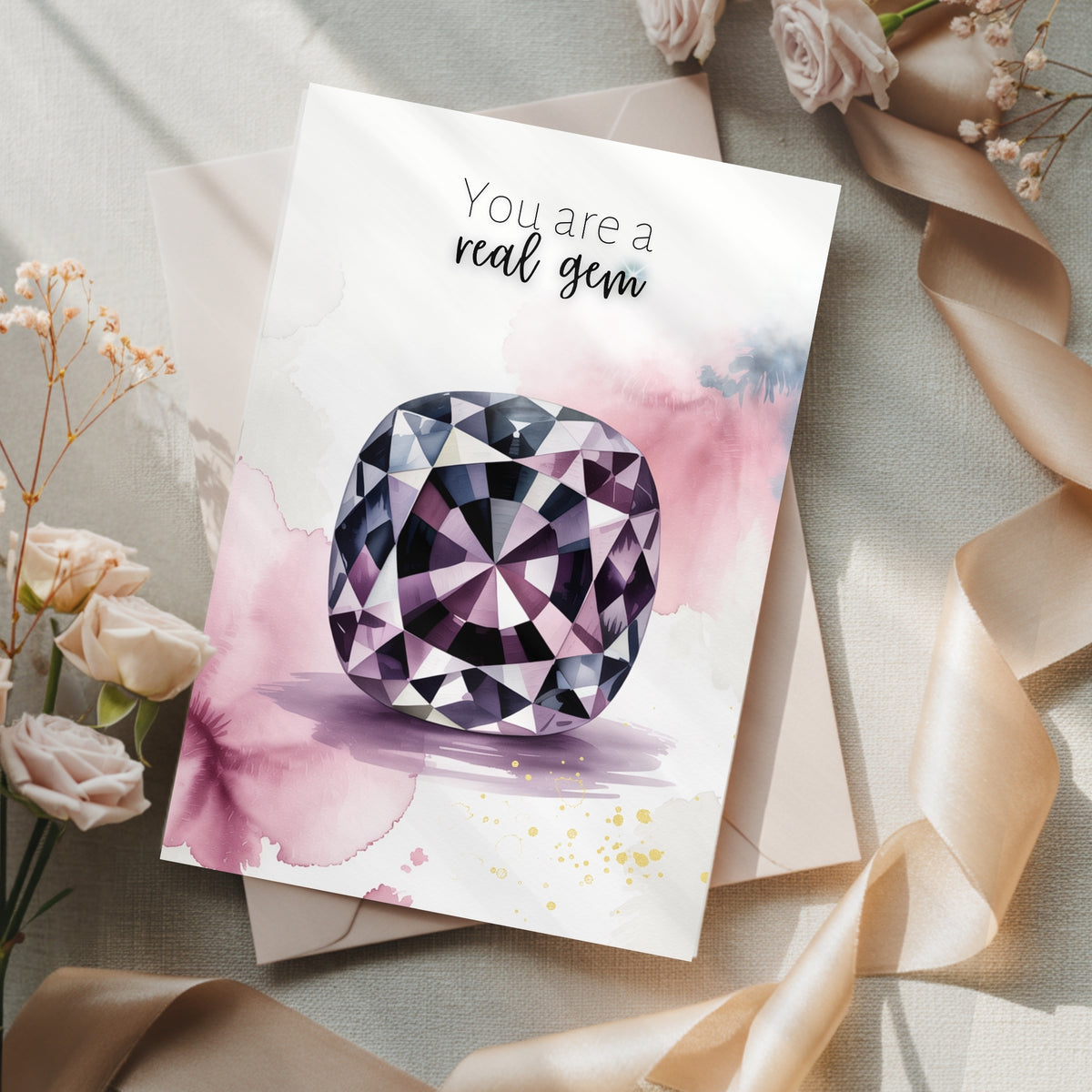Greeting card with a watercolor spinel illustration and 'You are a real gem' text, surrounded by flowers and ribbons.