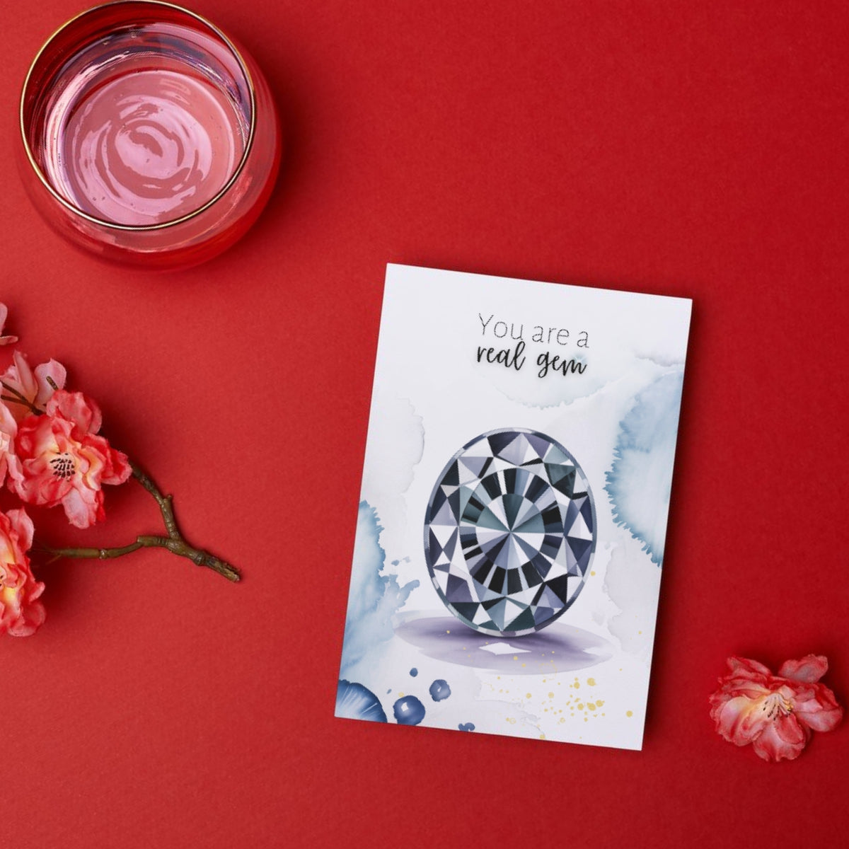 Greeting card with oval Spinel Gemstone illustration and 'You are a real gem' text on a red background with flowers and a candle.