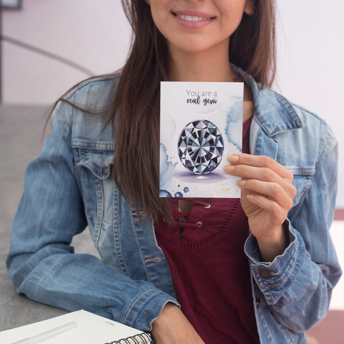 Woman holding a card with an oval Spinel Gemstone illustration and text.