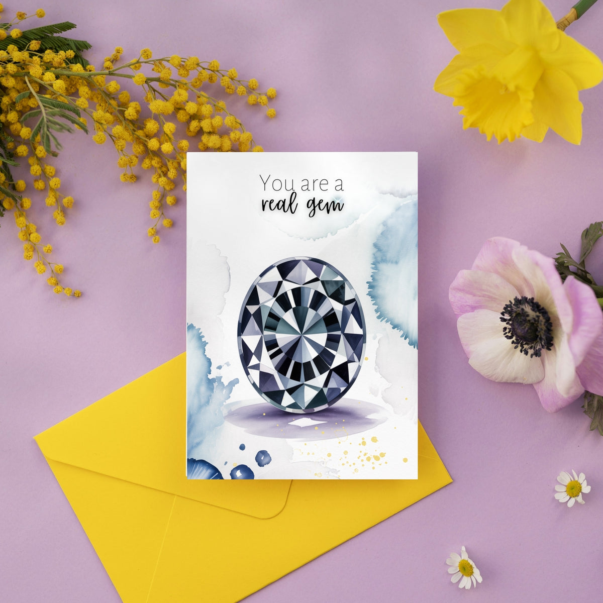 Greeting card with oval gemstone watercolor illustration and 'You are a real gem' text, surrounded by flowers on a purple background.