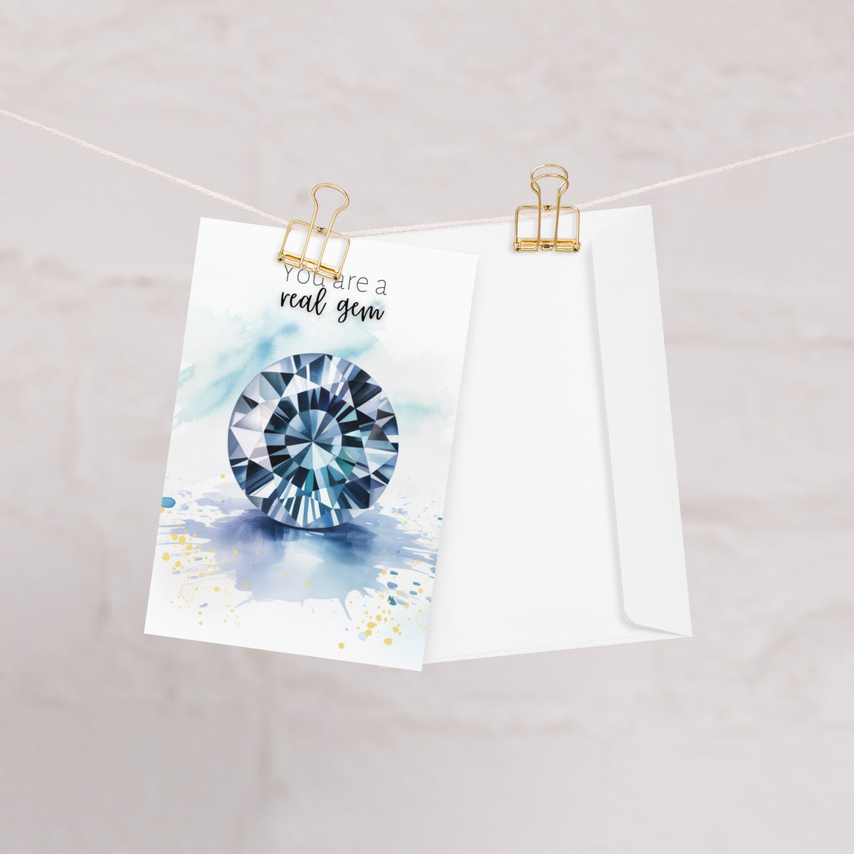 Envelope and Greeting card with a blue spinel illustration and text 'You are a real gem' hanging on a rope