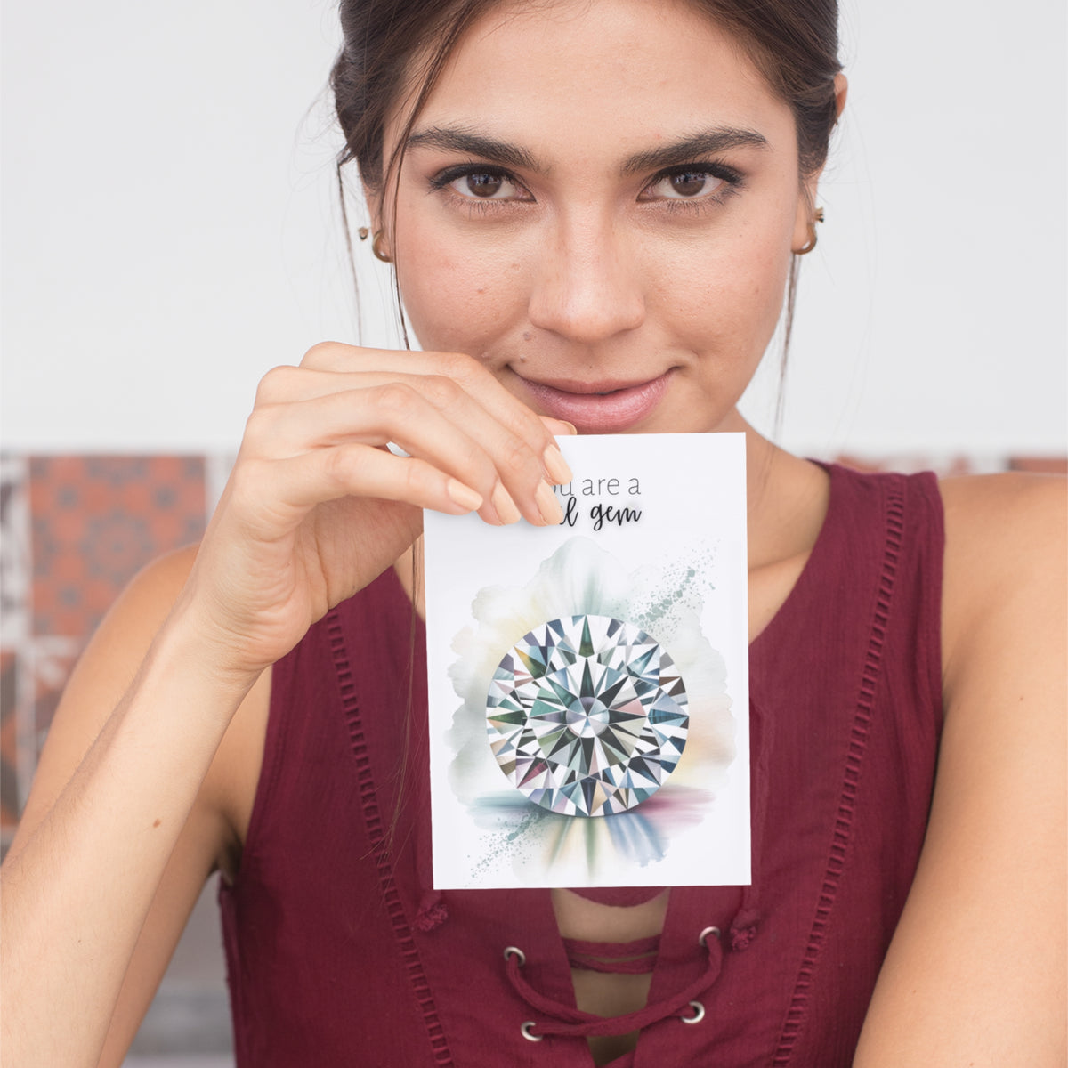 Woman holding a card with a diamond illustration and text.