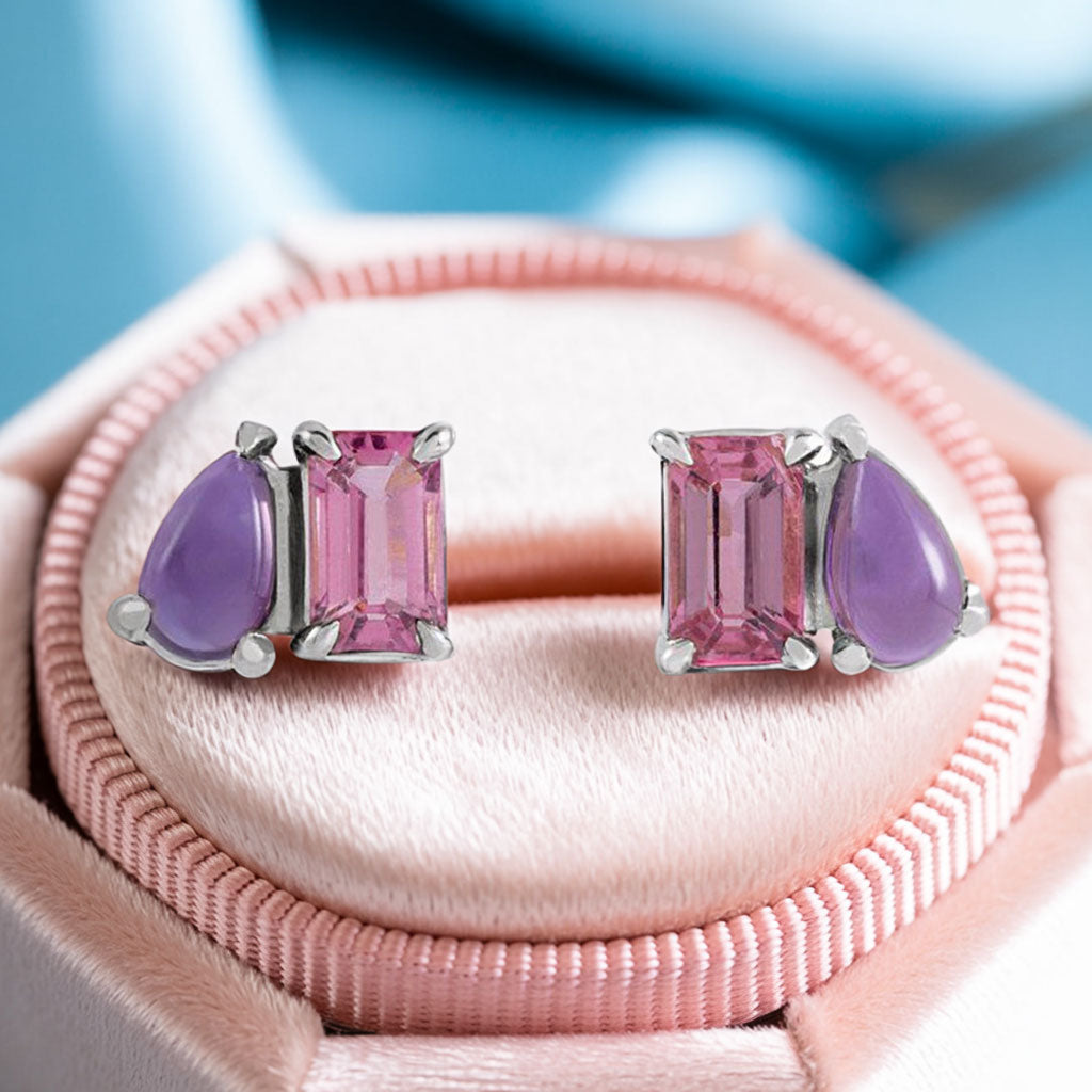 Emerald cut Pink Tourmaline & Pear Amethyst Two-Stone Birthstone Stud Earrings on a pink velvet box