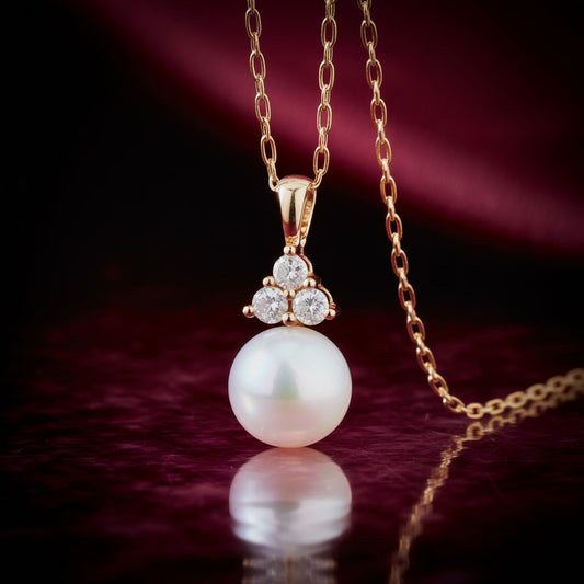 White Akoya Pearl Diamond Accented 14k Yellow Gold Dangle Pendant Necklace against dark red background
