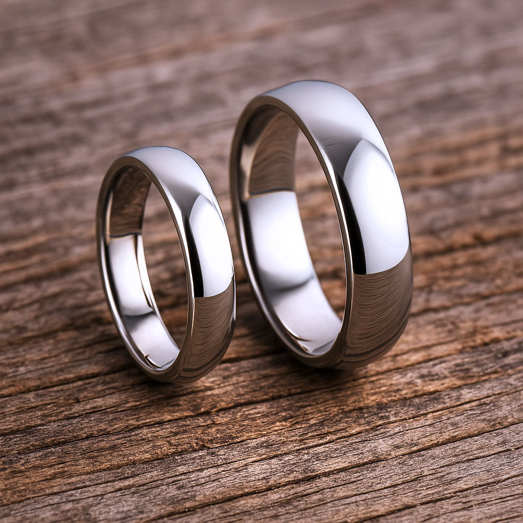 Sophisticated domed wedding rings by Nodeform placed on a textured wooden background.