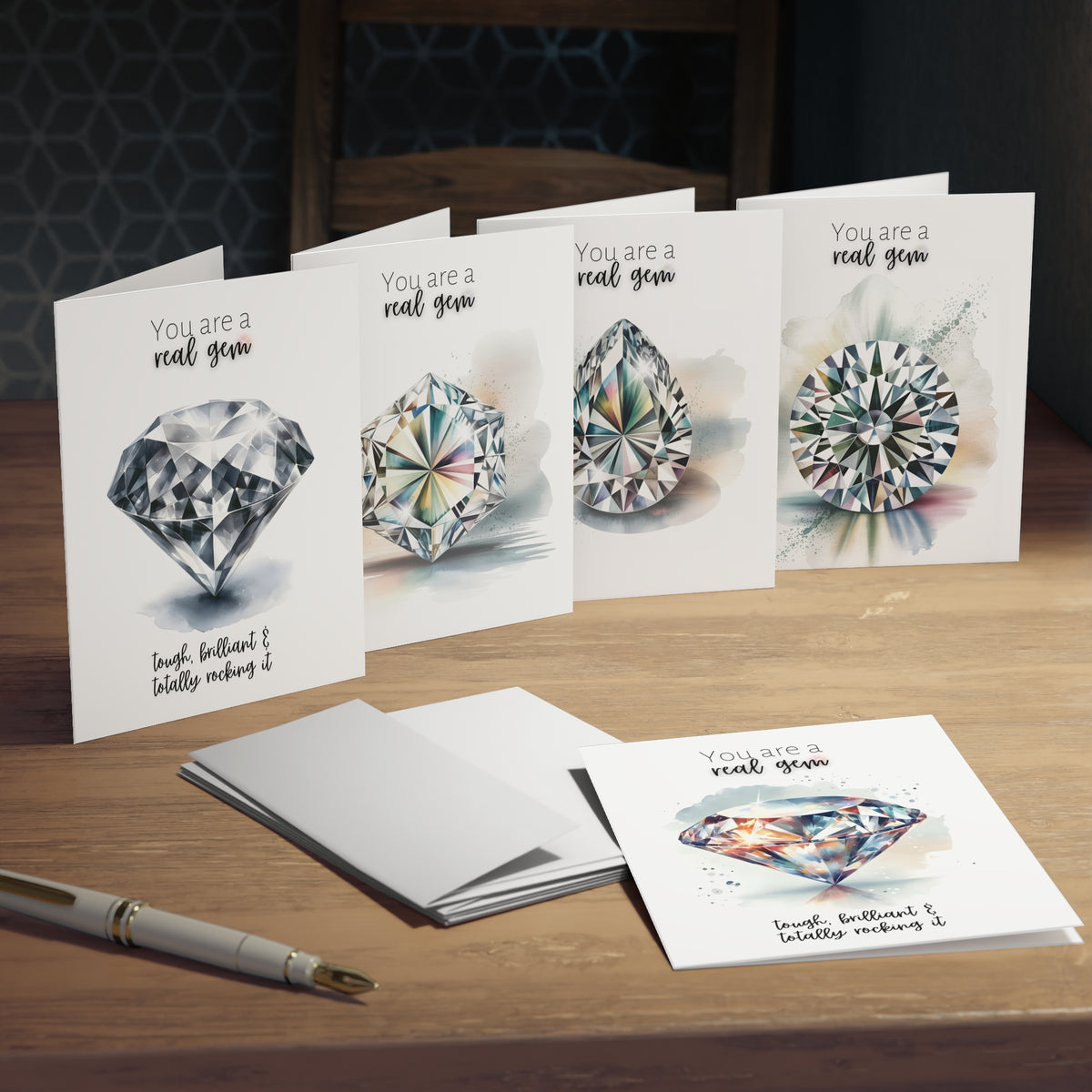 Set of greeting cards with diamond watercolor illustrations on a wooden surface.