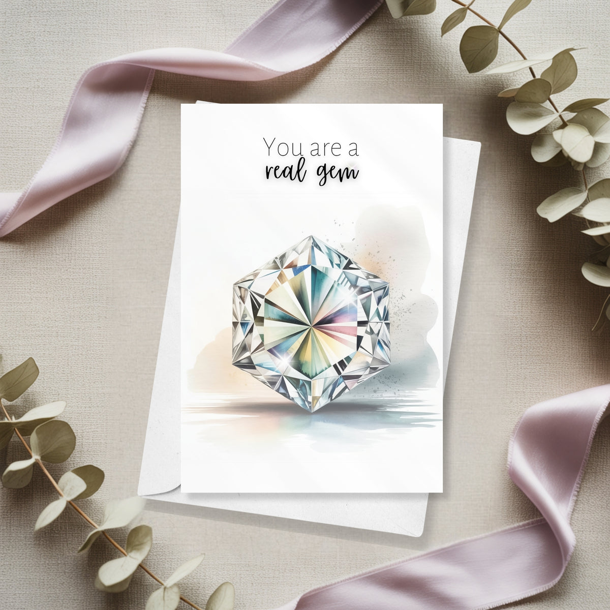 Greeting card with a hexagon diamond illustration and 'You are a real gem' text, surrounded by ribbons and eucalyptus leaves.