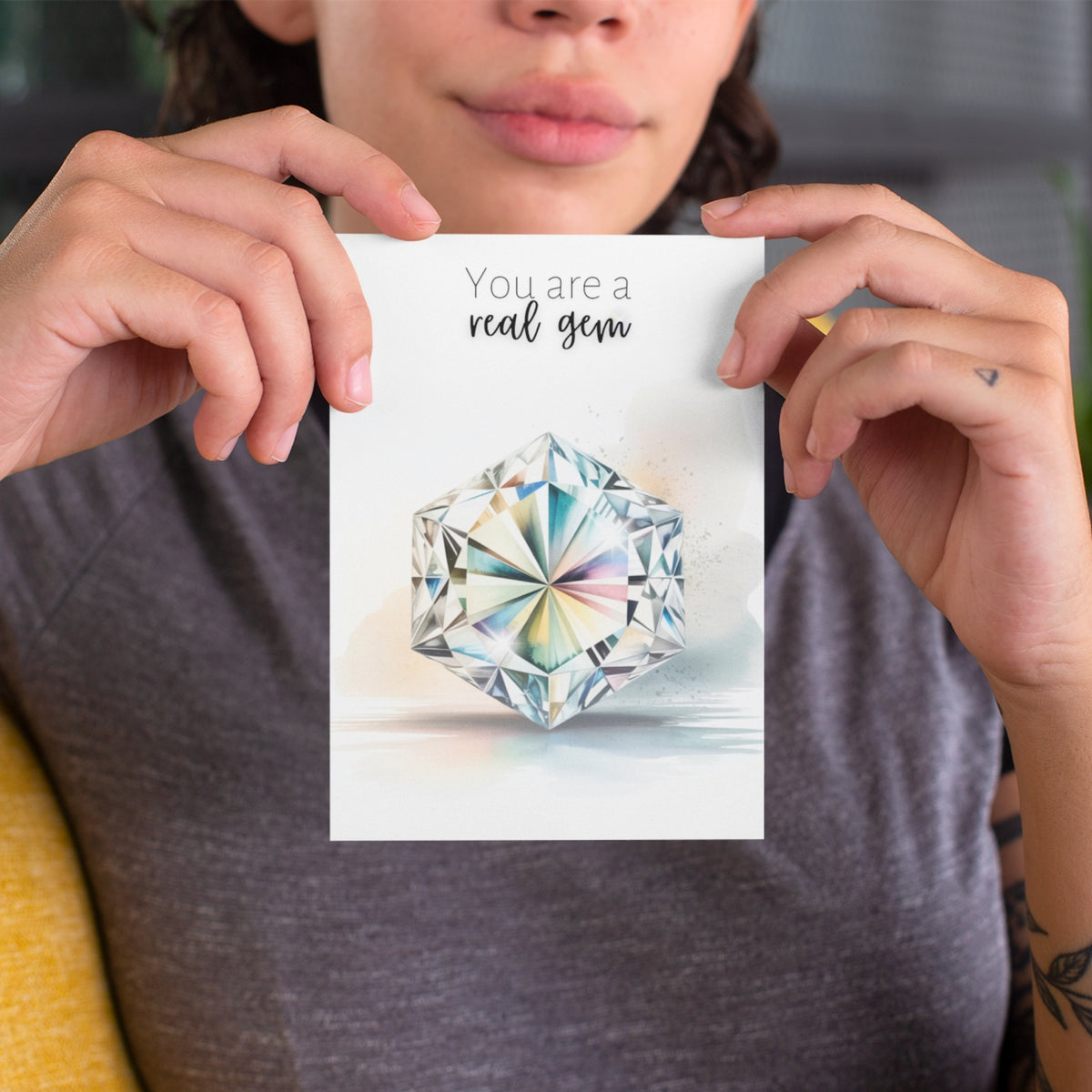 Person holding a card with a hexagon diamond illustration and text 'You are a real gem'.