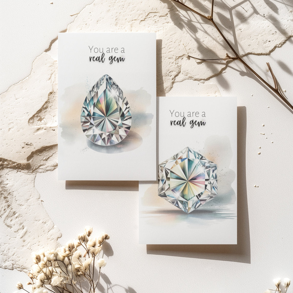 Two greeting cards with diamond illustrations and text on a light surface with decorative elements.