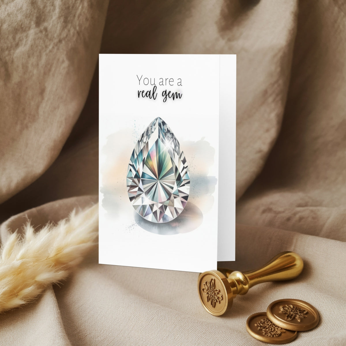 Greeting card with diamond illustration and 'You are a real gem' text on a textured fabric background.