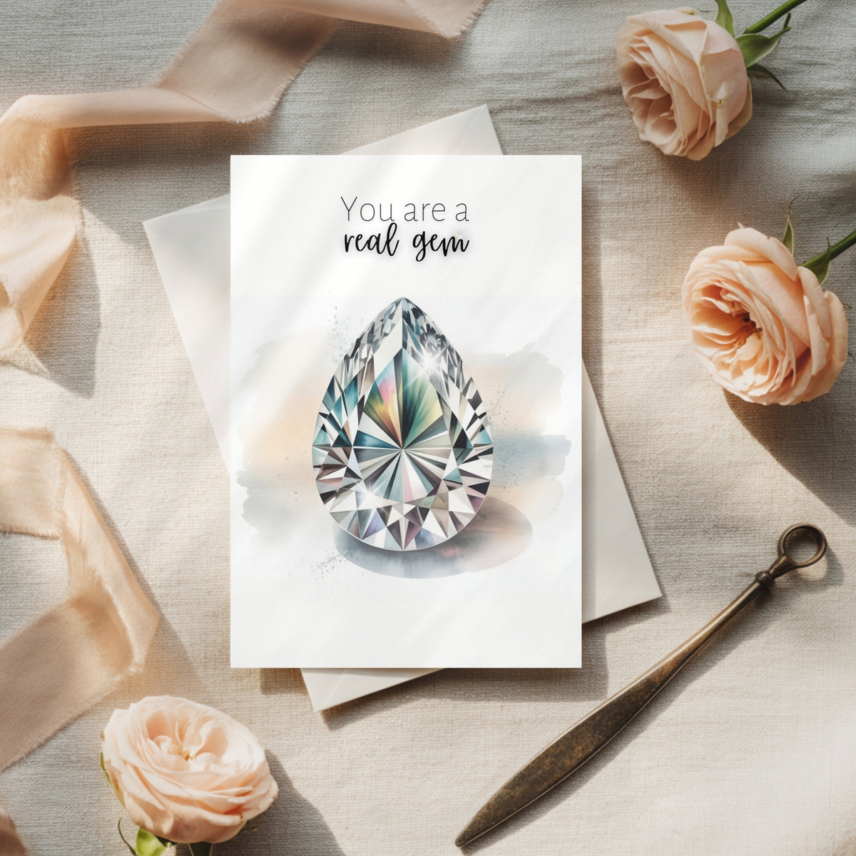 Greeting card with diamond illustration and 'You are a real gem' text, surrounded by flowers and ribbons on a textured surface.