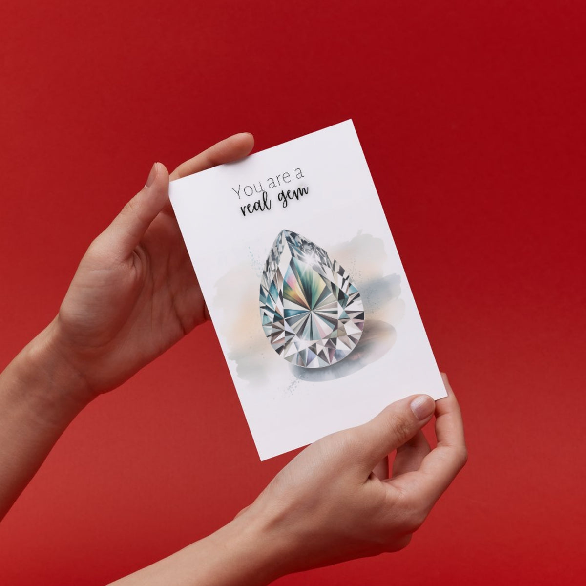 Hand holding a card with a diamond illustration and text on a red background