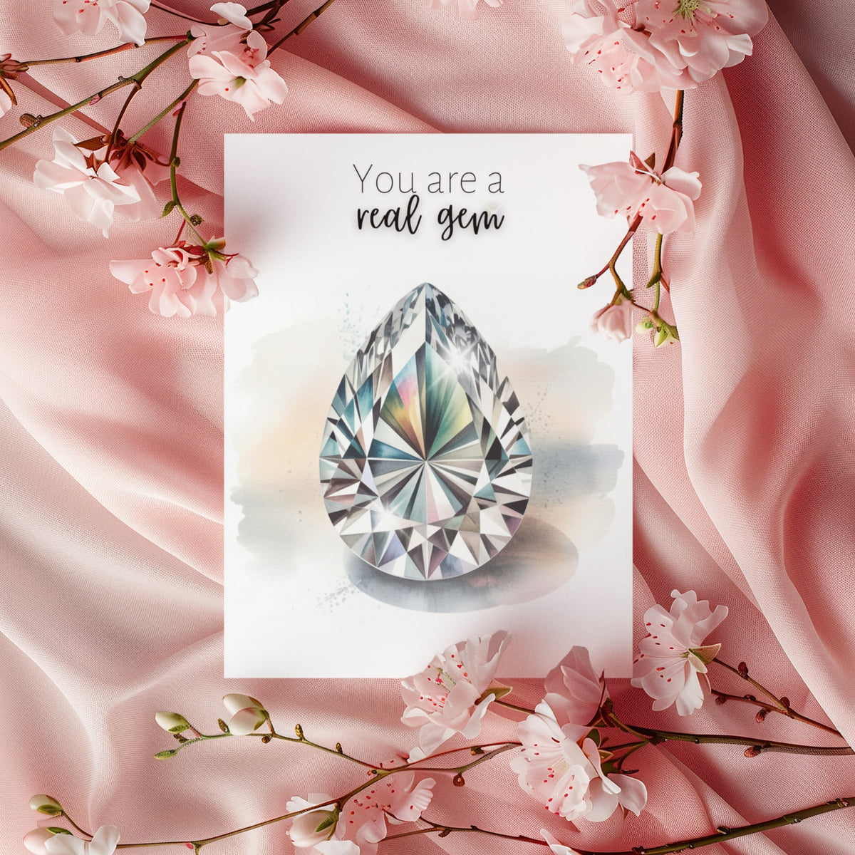 Card with a diamond illustration and 'You are a real gem' text, surrounded by pink fabric and cherry blossoms.