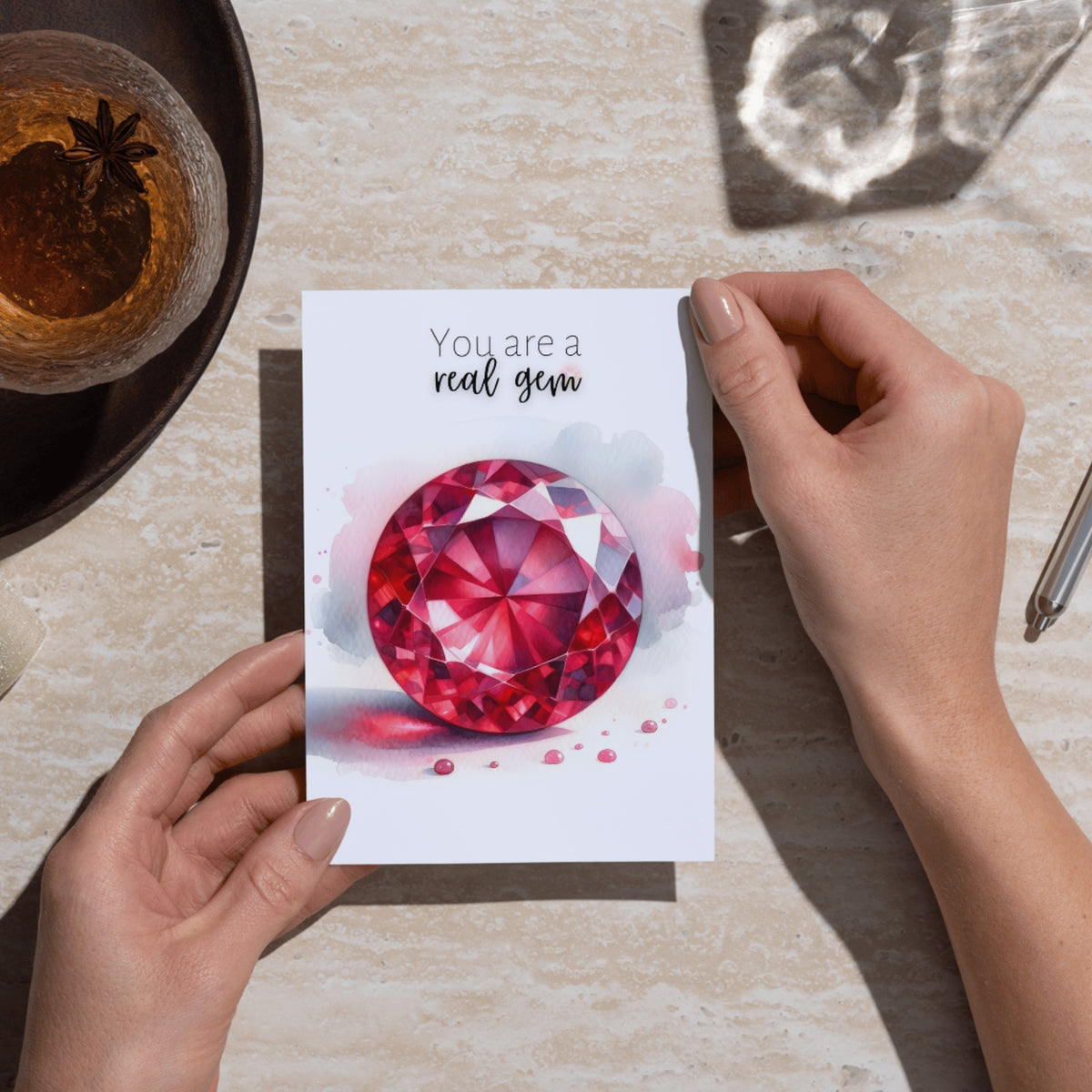 hands holding a You are a real Gem Watercolor Round Ruby Birthstone Greeting Thank you Card