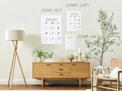 Modern living room with wooden cabinet, lamp, and decorative items and wall hung birthstone calendars in 3 sizes.