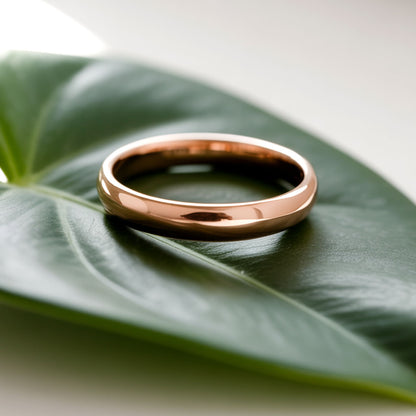 4mm wide simple domed wedding ring for men or women laying on a leaf