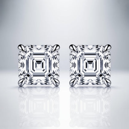 Pair of asscher cut diamond or moissanite  earrings on a white reflective surface with a light gray background