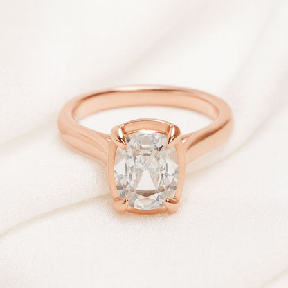 Taylor engagement ring  in rose gold with a large elongated antique cut cushion moissanite on a white fabric