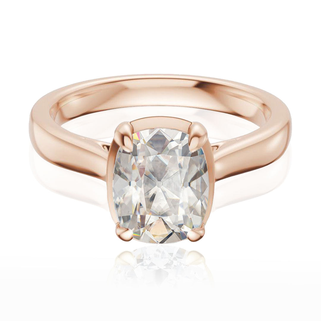 Taylor engagement ring  in rose gold with a large elongated antique cut cushion moissanite on a white reflective background