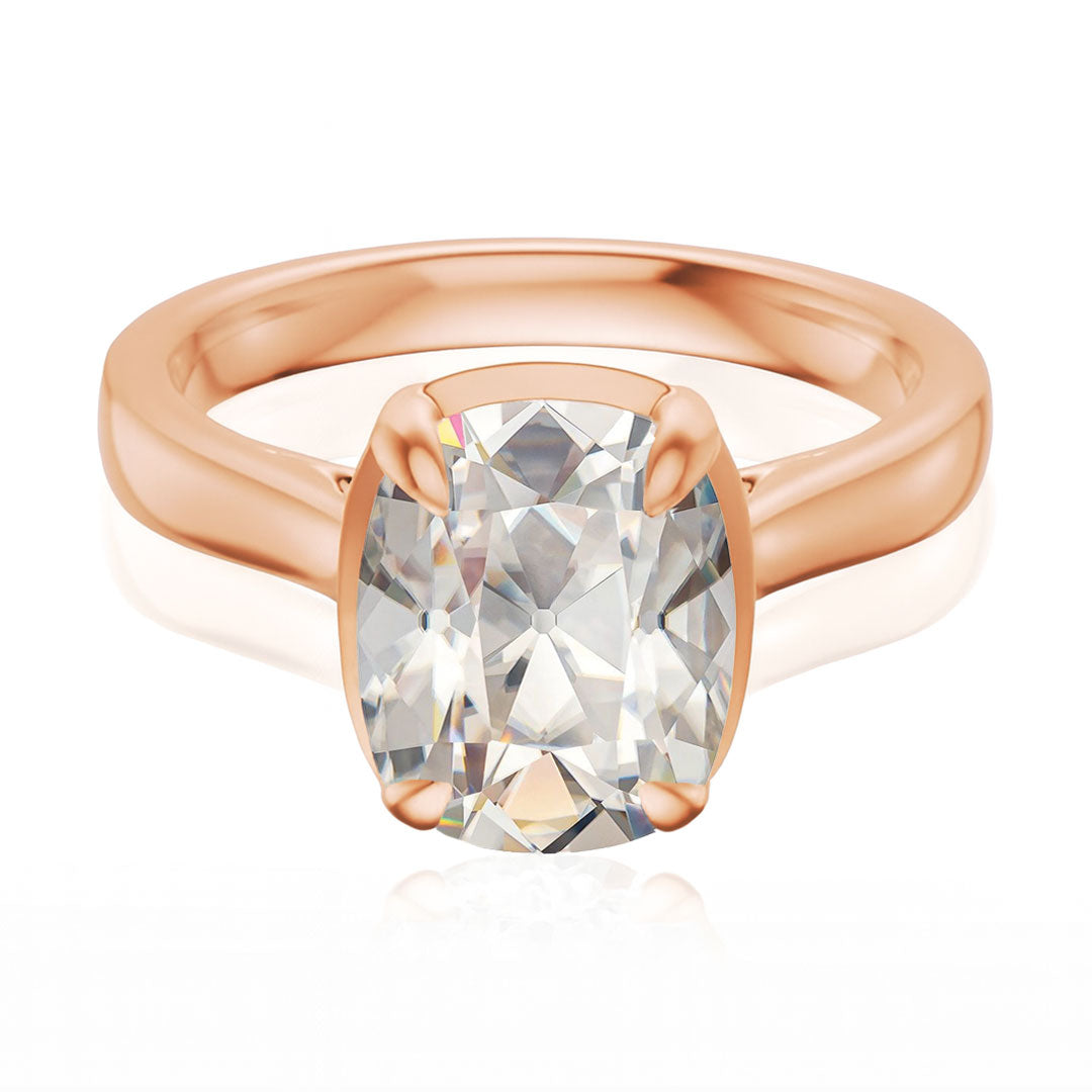 Taylor engagement ring  in rose gold with a large elongated antique cut cushion moissanite on a white reflective background