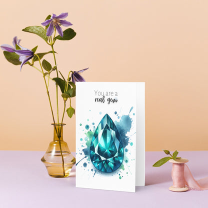 Watercolor Pear Teal Sapphire You are a Real Gem Greeting Card next to vase