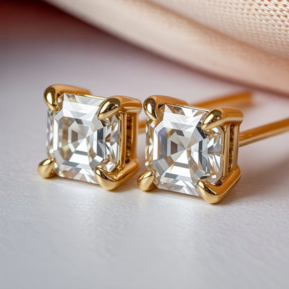 Gold earrings with asscher cut moissanite or diamond on a light background