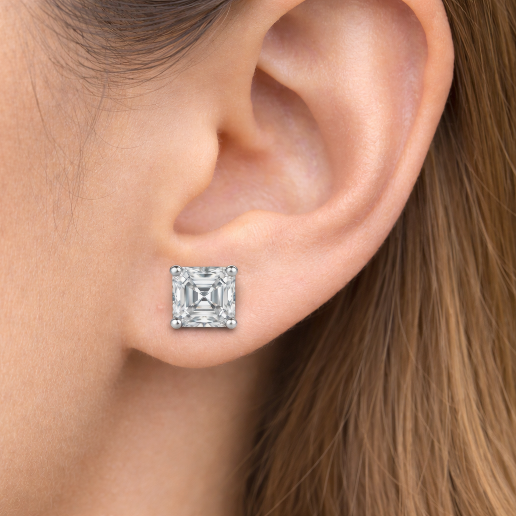 Close-up of an ear wearing a diamond stud earring with a blurred background