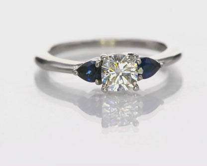 Tressa- Three Stone Engagement Ring, Prong set Cushion Moissanite & Pear Blue Sapphire Accents